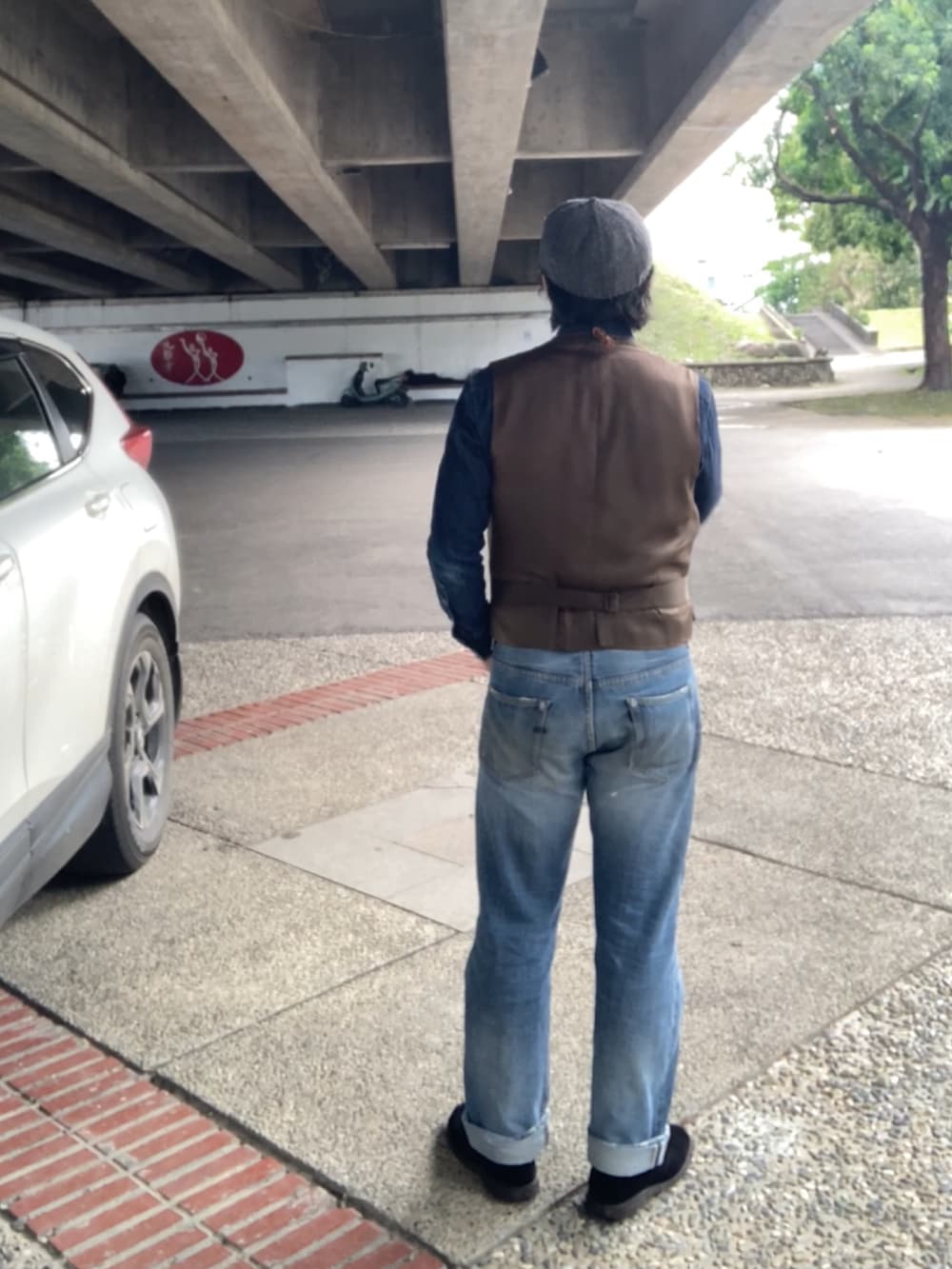 グリーン系のベスト、ブルー系のシャツ/ブラウス、ブルー系のデニムパンツを着用したメンズの春コーディネートの3枚目の写真