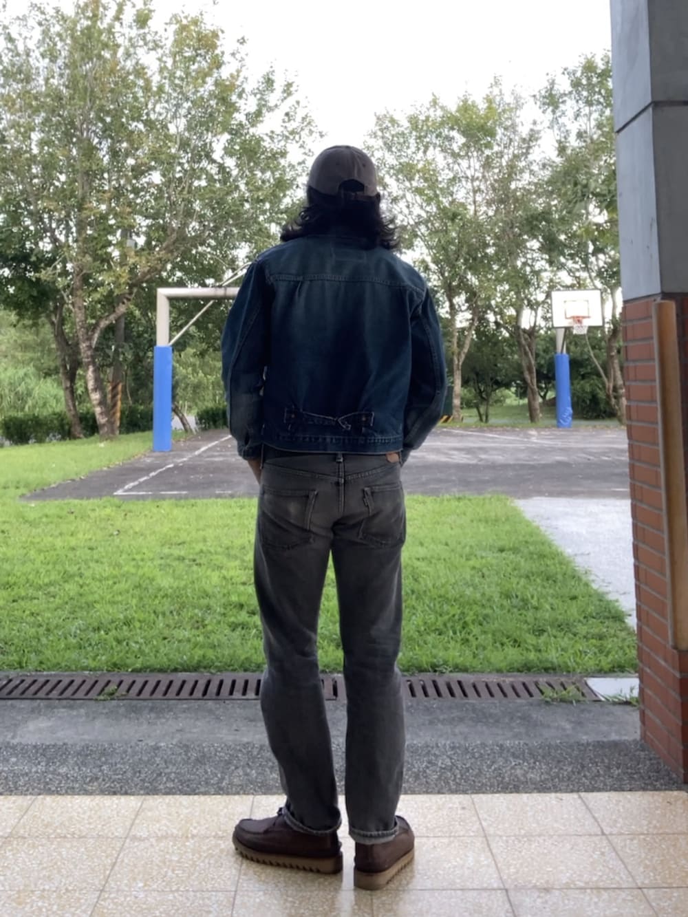 ブルー系のデニムジャケット、ブラック系のデニムパンツ、ブラウン系のブーツを着用したメンズの秋コーディネートの2枚目の写真