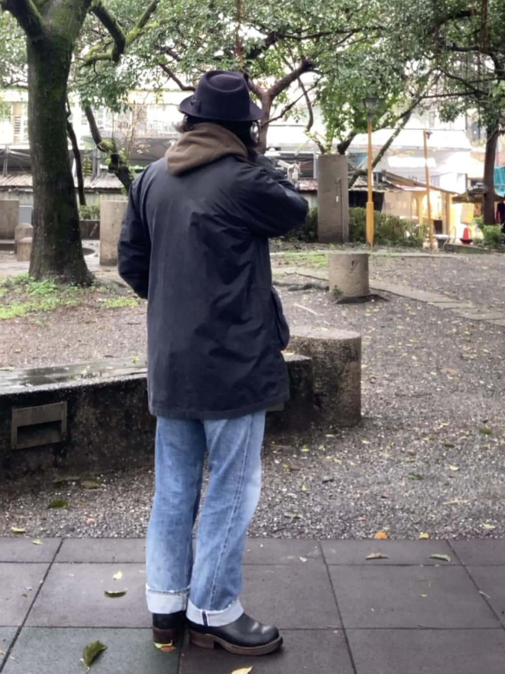 ブルー系のデニムパンツ、ブラック系のブーツ、ブラウン系のベストを着用したメンズの冬コーディネートの2枚目の写真