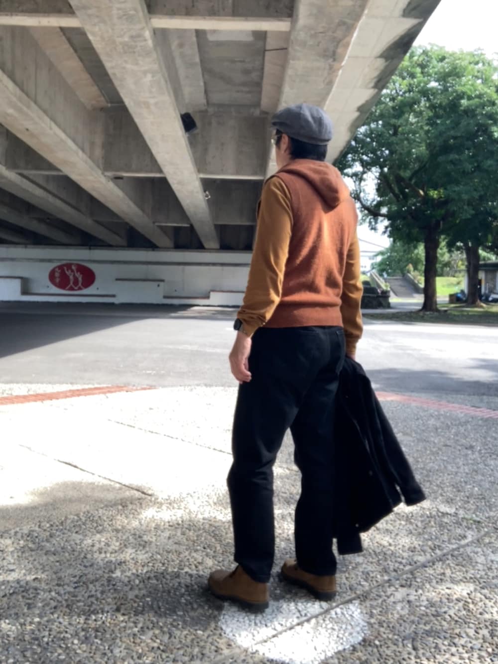 ブラウン系のベスト、ブラウン系のTシャツ/カットソー、ブラック系のカバーオールを着用したメンズの冬コーディネートの3枚目の写真