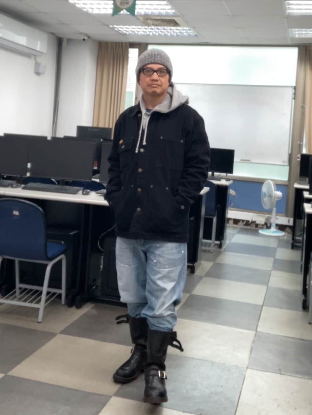 ブラック系のブーツ、ブラック系のカバーオール、グレー系のパーカーを着用したメンズの冬コーディネートの2枚目の写真