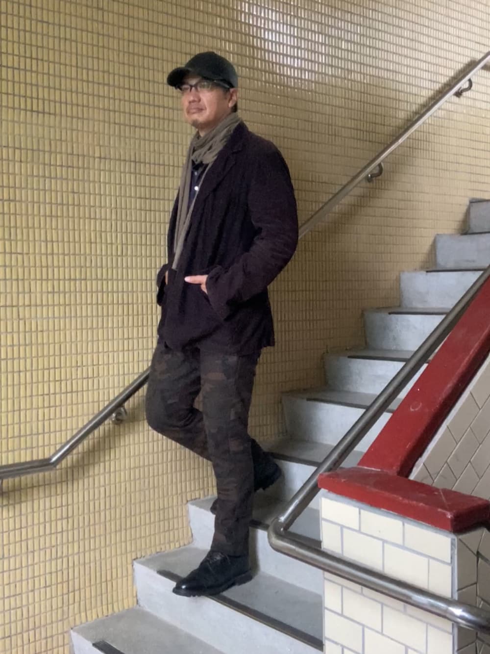 ブラック系のテーラードジャケット、ブルー系のシャツ/ブラウス、ブラック系のブーツを着用したメンズの春コーディネートの2枚目の写真