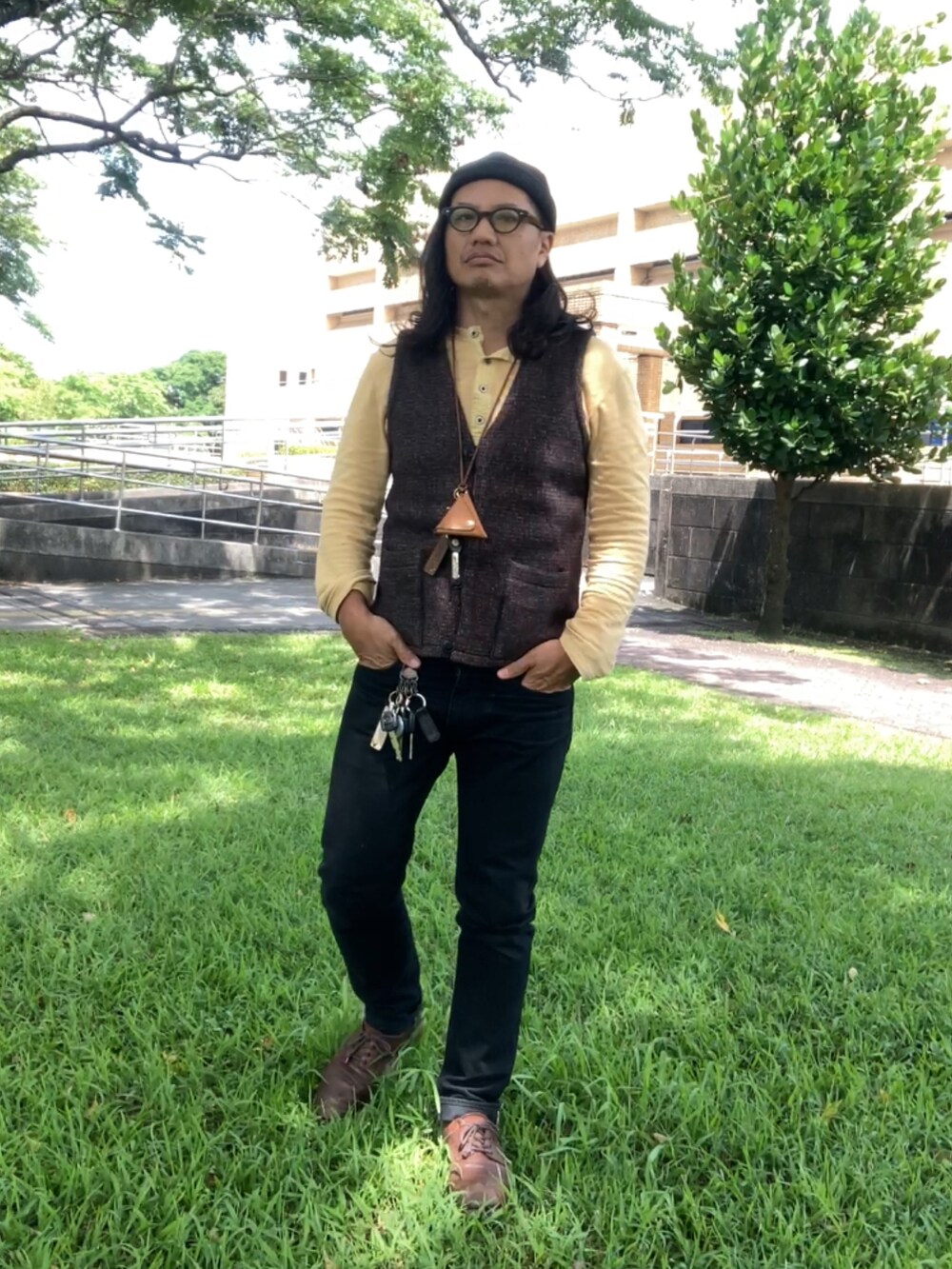 ブラウン系のベスト、ブラック系のデニムパンツ、ブラウン系のその他シューズを着用したメンズの春コーディネートの3枚目の写真