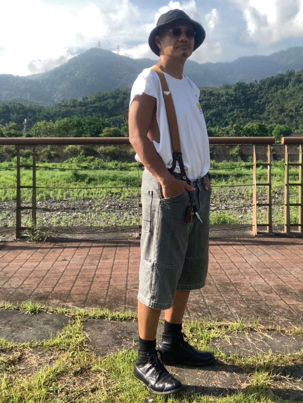 ホワイト系のTシャツ/カットソー、ブラック系のデニムパンツ、ブラック系のブーツを着用したメンズの夏コーディネートの2枚目の写真