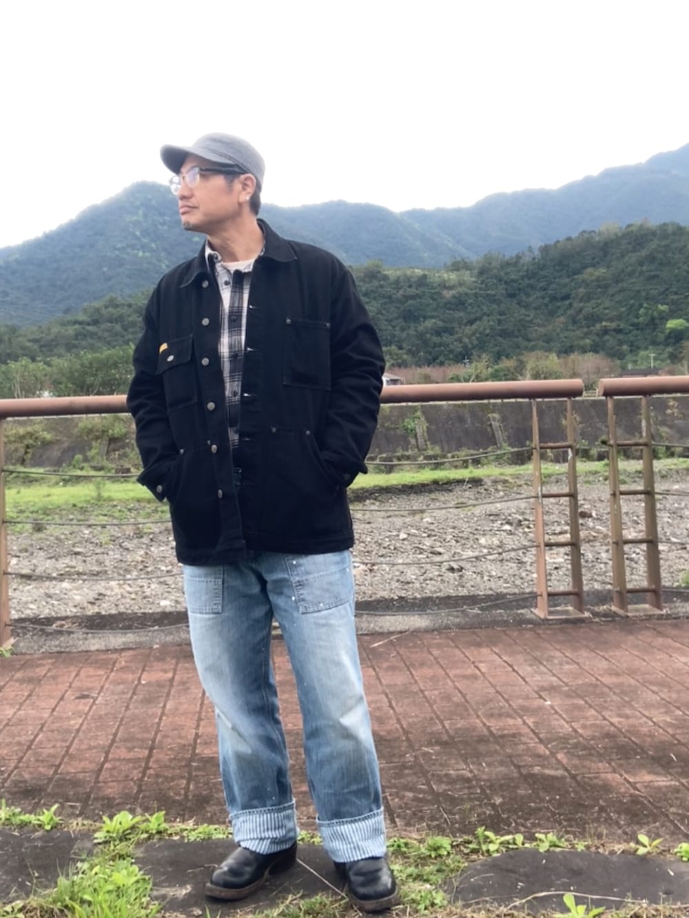 ブラック系のカバーオール、ブルー系のデニムパンツ、ブラック系のブーツを着用したメンズの冬コーディネートの3枚目の写真