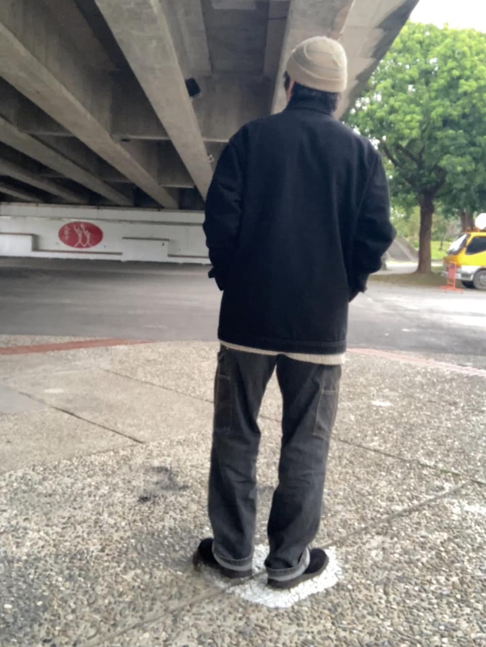 ブラック系のカバーオール、ベージュ系のニット/セーター、ブラック系のデニムパンツを着用したメンズの冬コーディネートの3枚目の写真