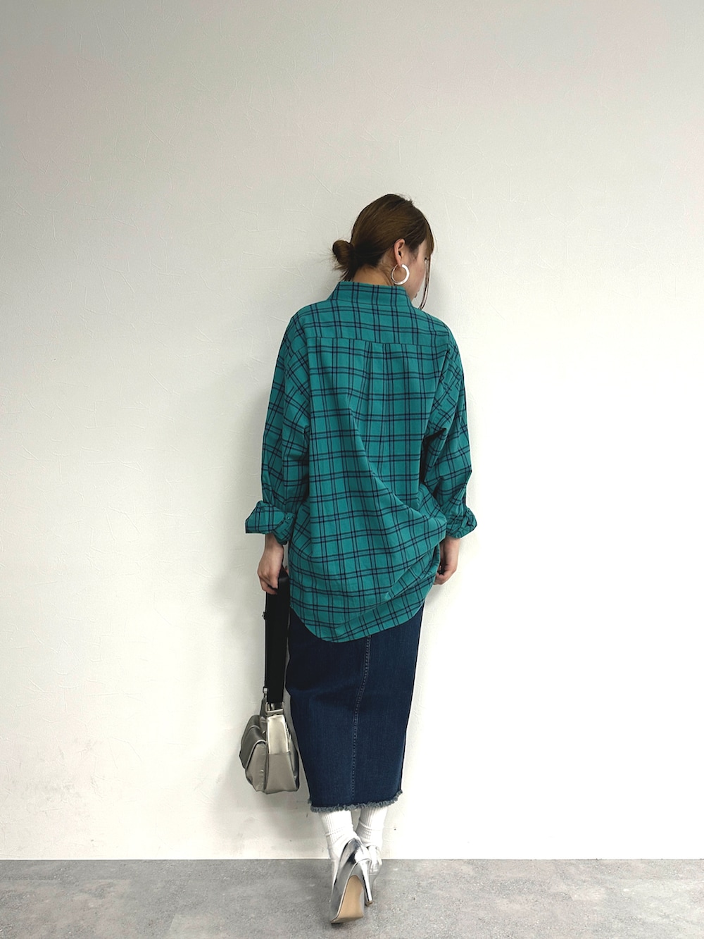 グリーン系のトップス、ブルー系のデニムスカート、シルバー系のパンプスを着用したレディースの春コーディネートの4枚目の写真