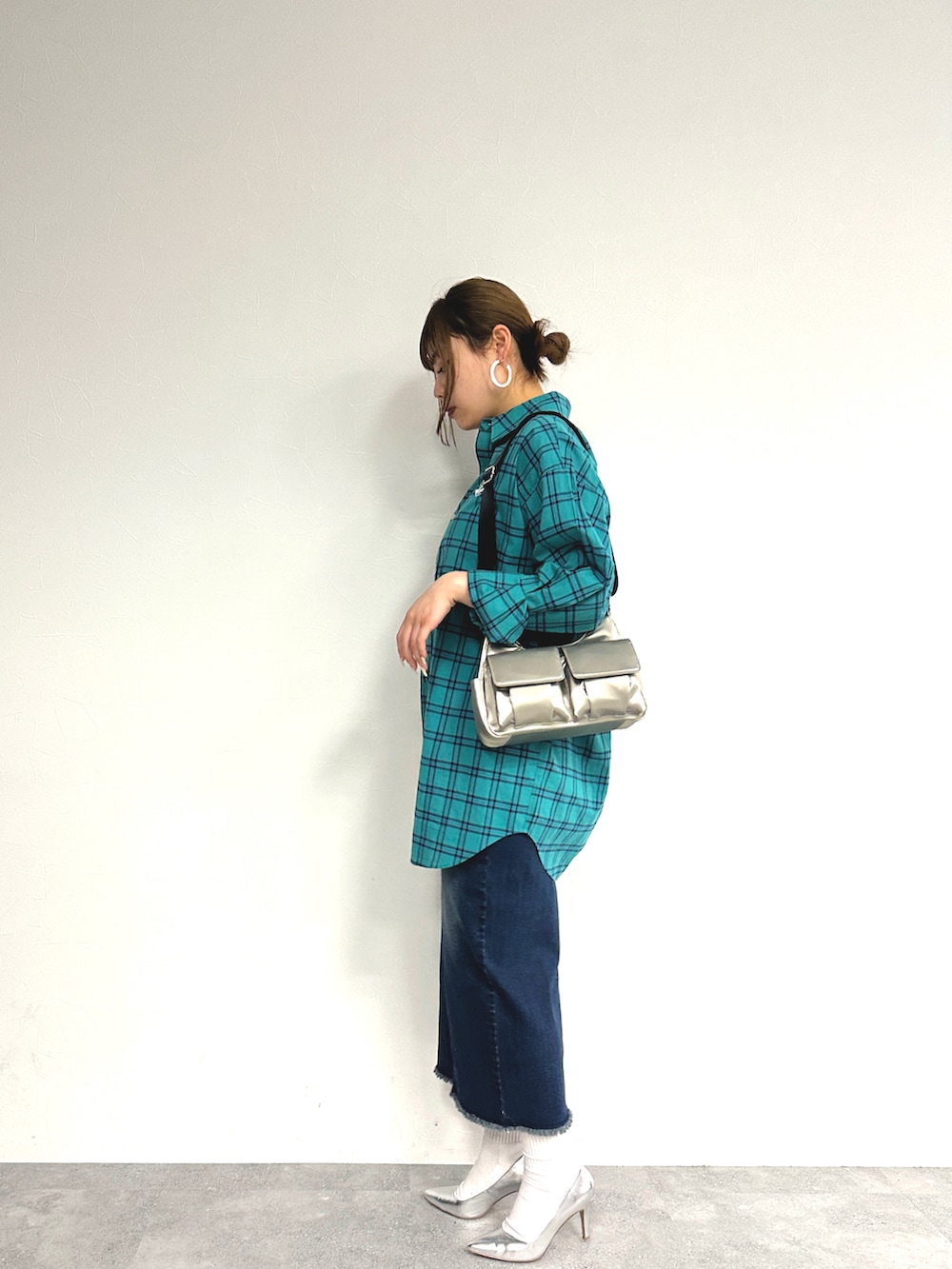 グリーン系のトップス、ブルー系のデニムスカート、シルバー系のパンプスを着用したレディースの春コーディネートの3枚目の写真