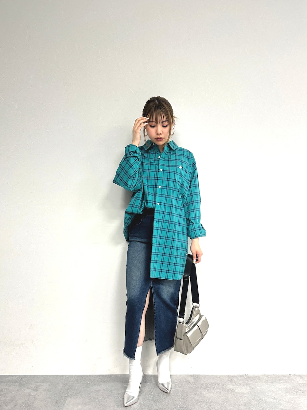 グリーン系のトップス、ブルー系のデニムスカート、シルバー系のパンプスを着用したレディースの春コーディネートの2枚目の写真