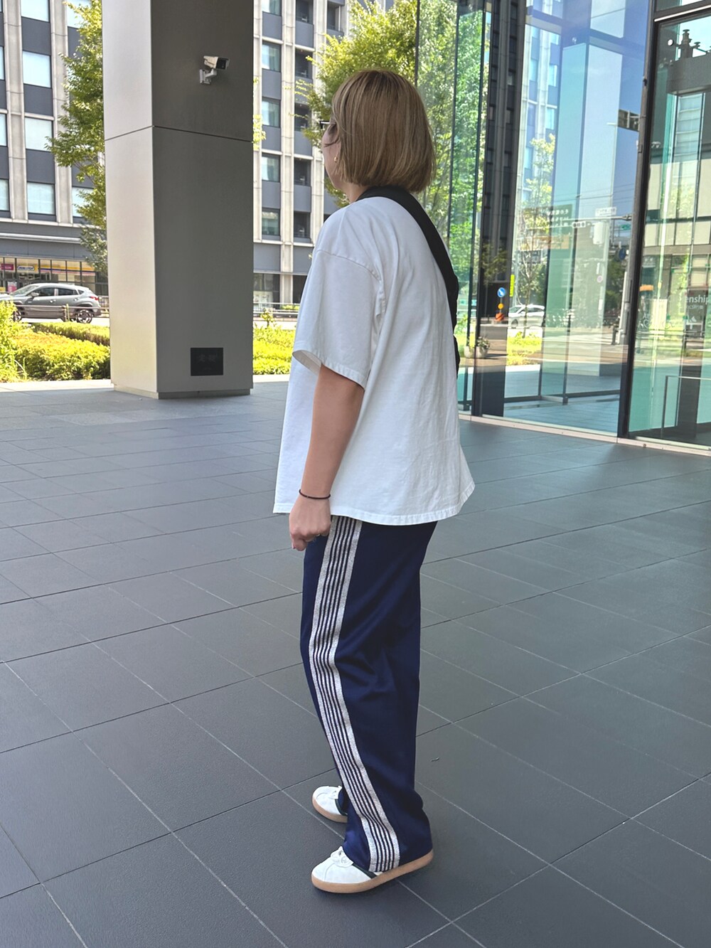 ブルー系のその他パンツ、ホワイト系のスニーカー、ホワイト系のTシャツ/カットソーを着用したレディースの夏コーディネートの2枚目の写真