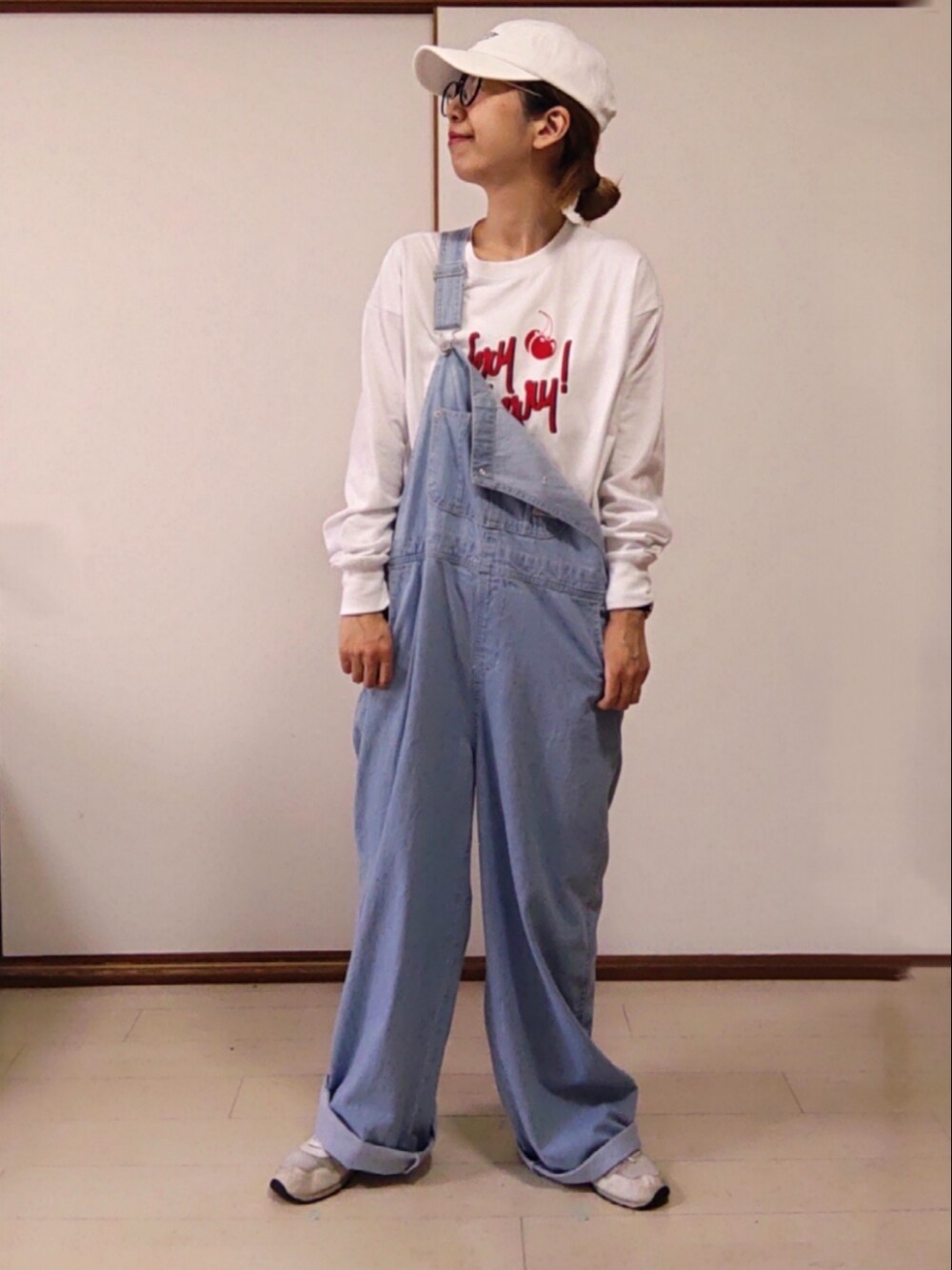 ホワイト系のハンドバッグ、ホワイト系のTシャツ/カットソー、ブルー系のサロペット/オーバーオールを着用したレディースの春コーディネートの2枚目の写真