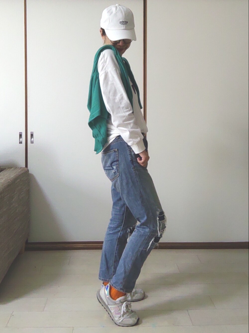 ブルー系のデニムパンツ、ホワイト系のスニーカー、ホワイト系のTシャツ/カットソーを着用したレディースの春コーディネートの3枚目の写真