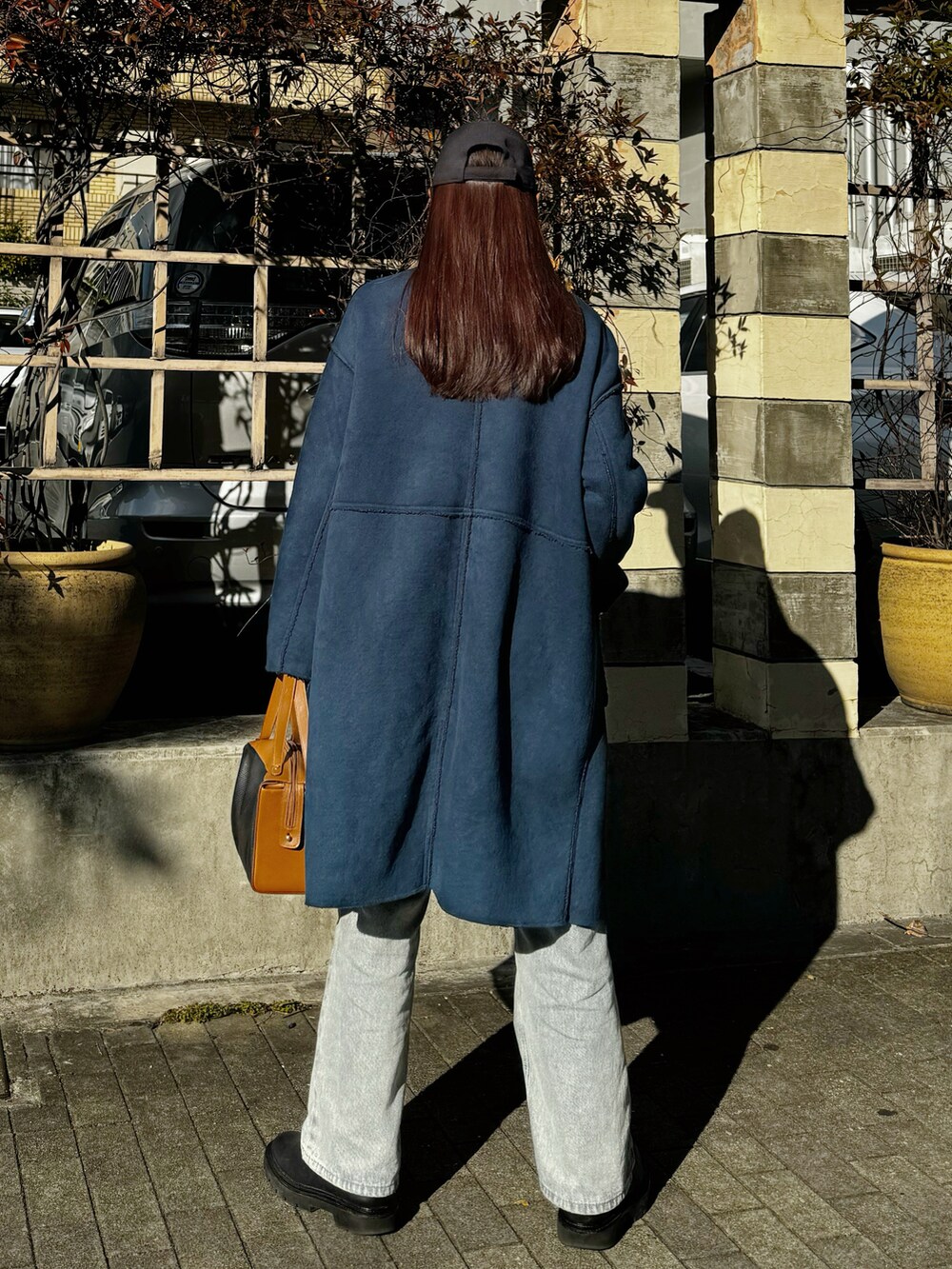 その他のショルダーバッグ、ブラック系のブーツ、ホワイト系のニット/セーターを着用したレディースの冬コーディネートの2枚目の写真