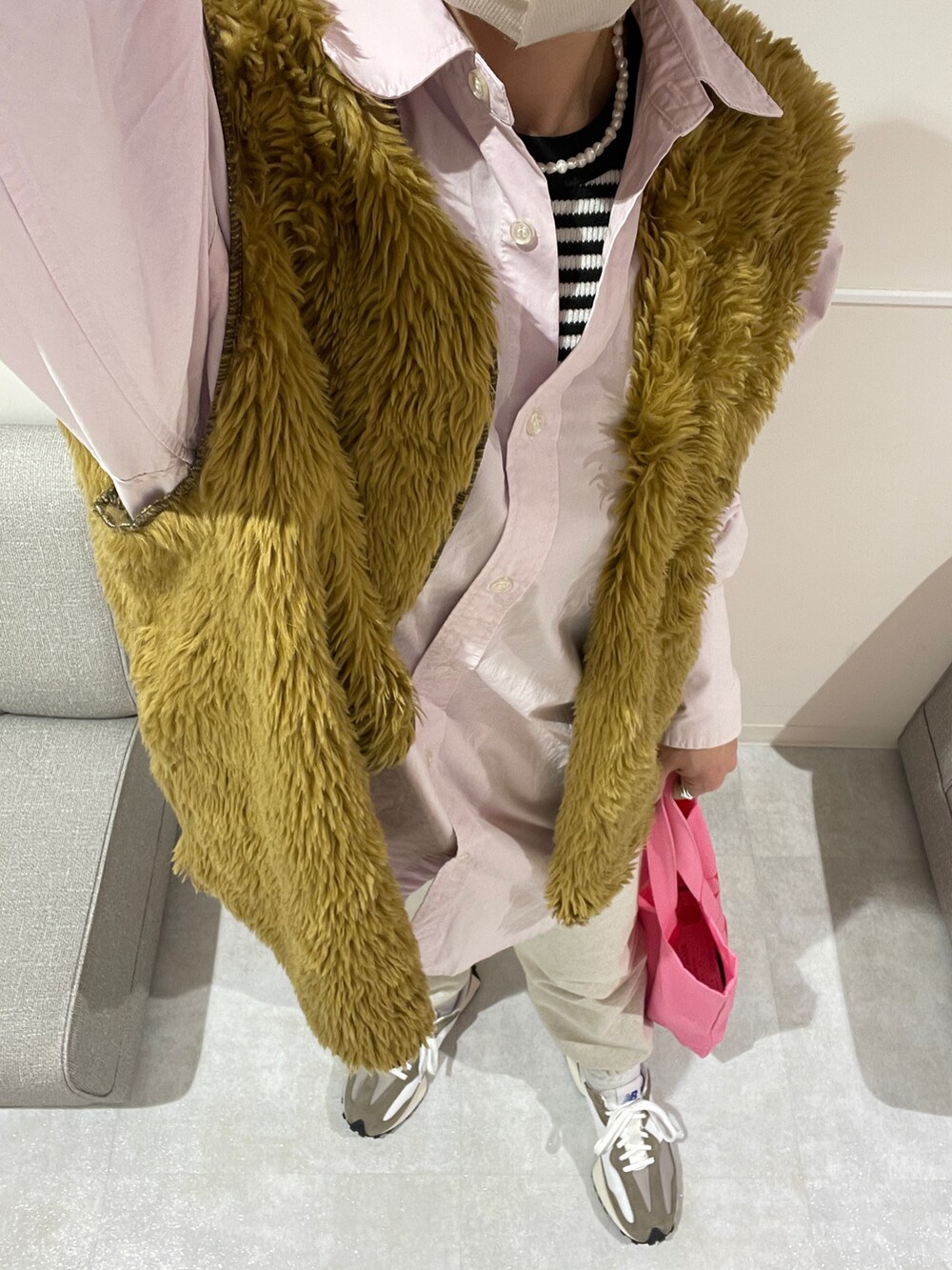 ピンク系のトートバッグ、ピンク系のシャツ/ブラウス、ブラウン系のベストを着用したレディースの冬コーディネートの2枚目の写真