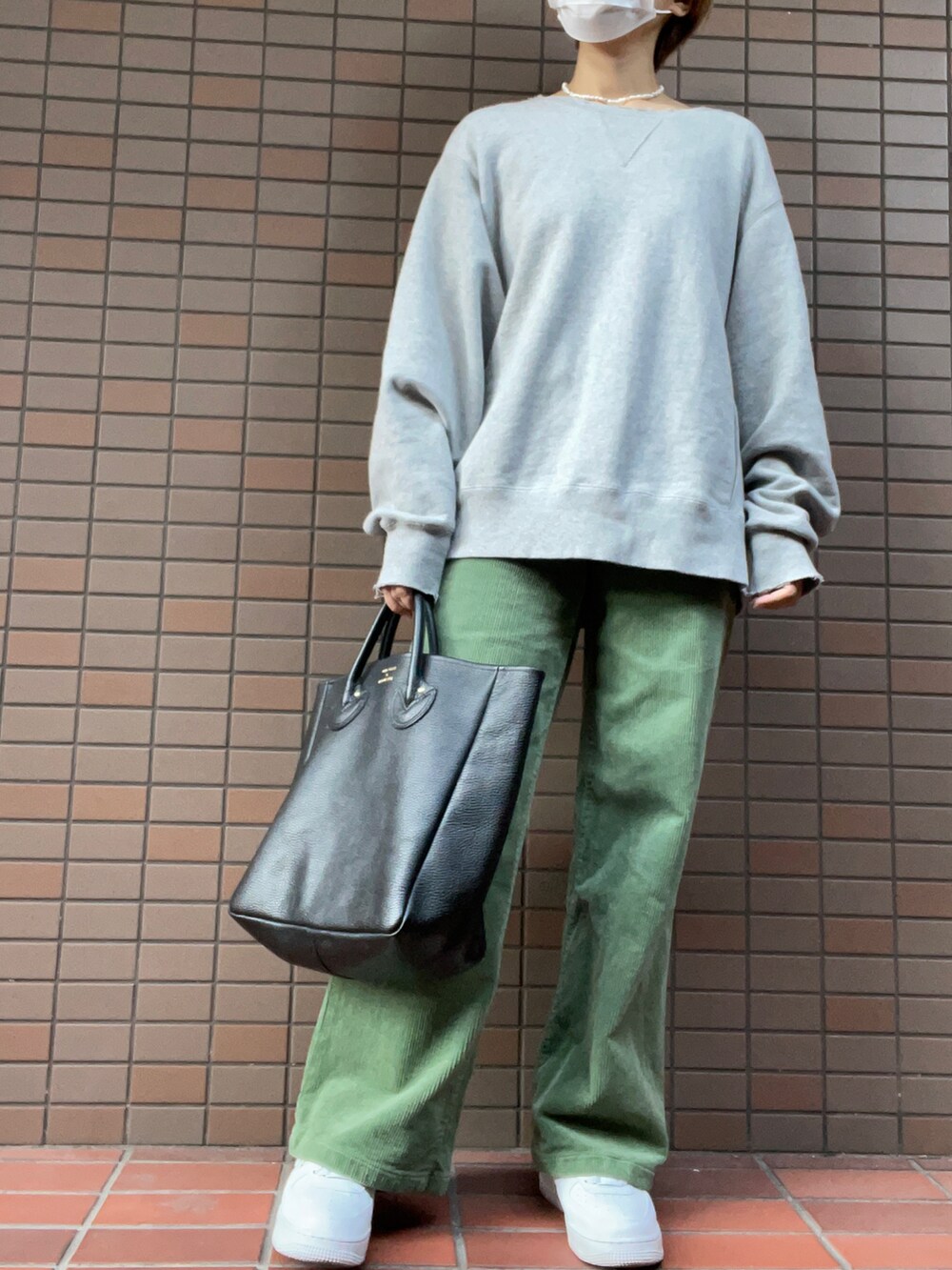 ブラック系のトートバッグ、グレー系のその他パンツ、ホワイト系のスニーカーを着用したレディースの秋コーディネートの2枚目の写真