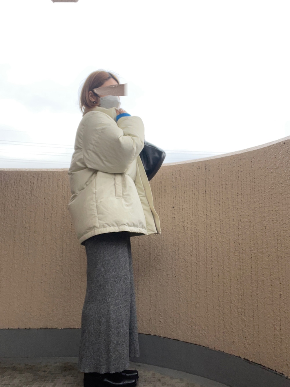 ブルー系のスウェット、ホワイト系のダウンジャケット/コート、ホワイト系のトップスを着用したレディースの冬コーディネートの2枚目の写真