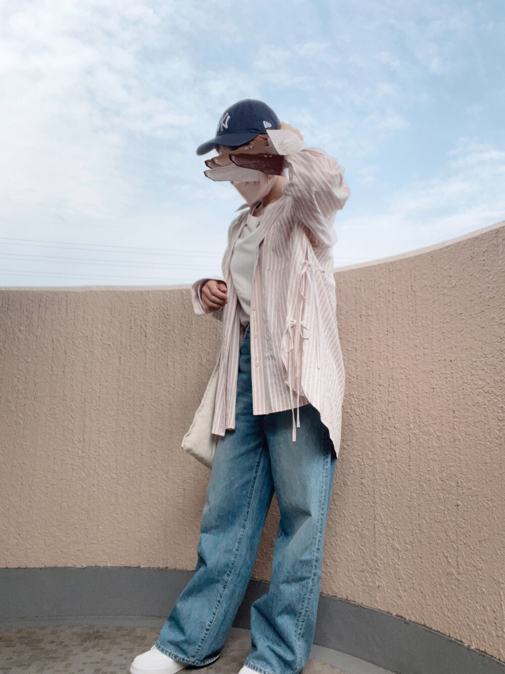 ホワイト系のスニーカー、ベージュ系のショルダーバッグ、ホワイト系のTシャツ/カットソーを着用したレディースの春コーディネートの2枚目の写真