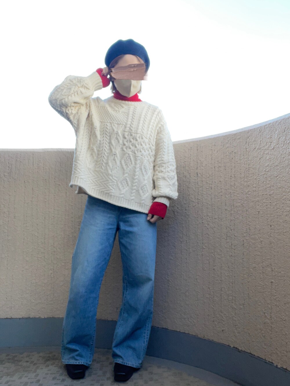 ブルー系のデニムパンツ、ブラック系のブーツ、ホワイト系のニット/セーターを着用したレディースの冬コーディネートの2枚目の写真