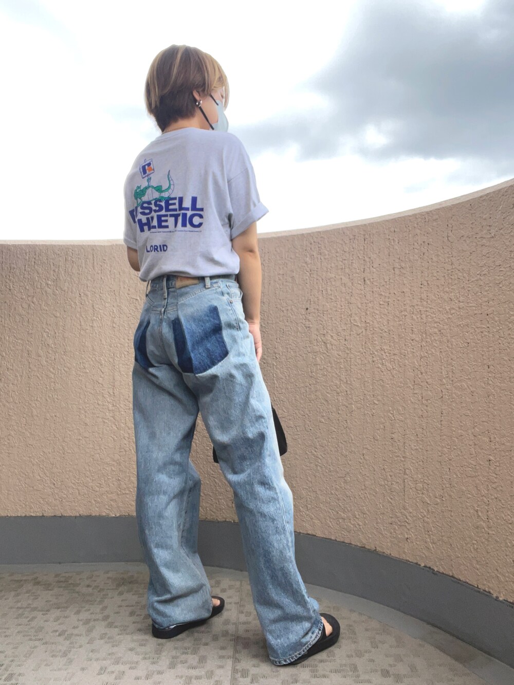 グレー系のTシャツ/カットソー、ブラック系のサンダル、ブラック系のハンドバッグを着用したレディースの夏コーディネートの2枚目の写真