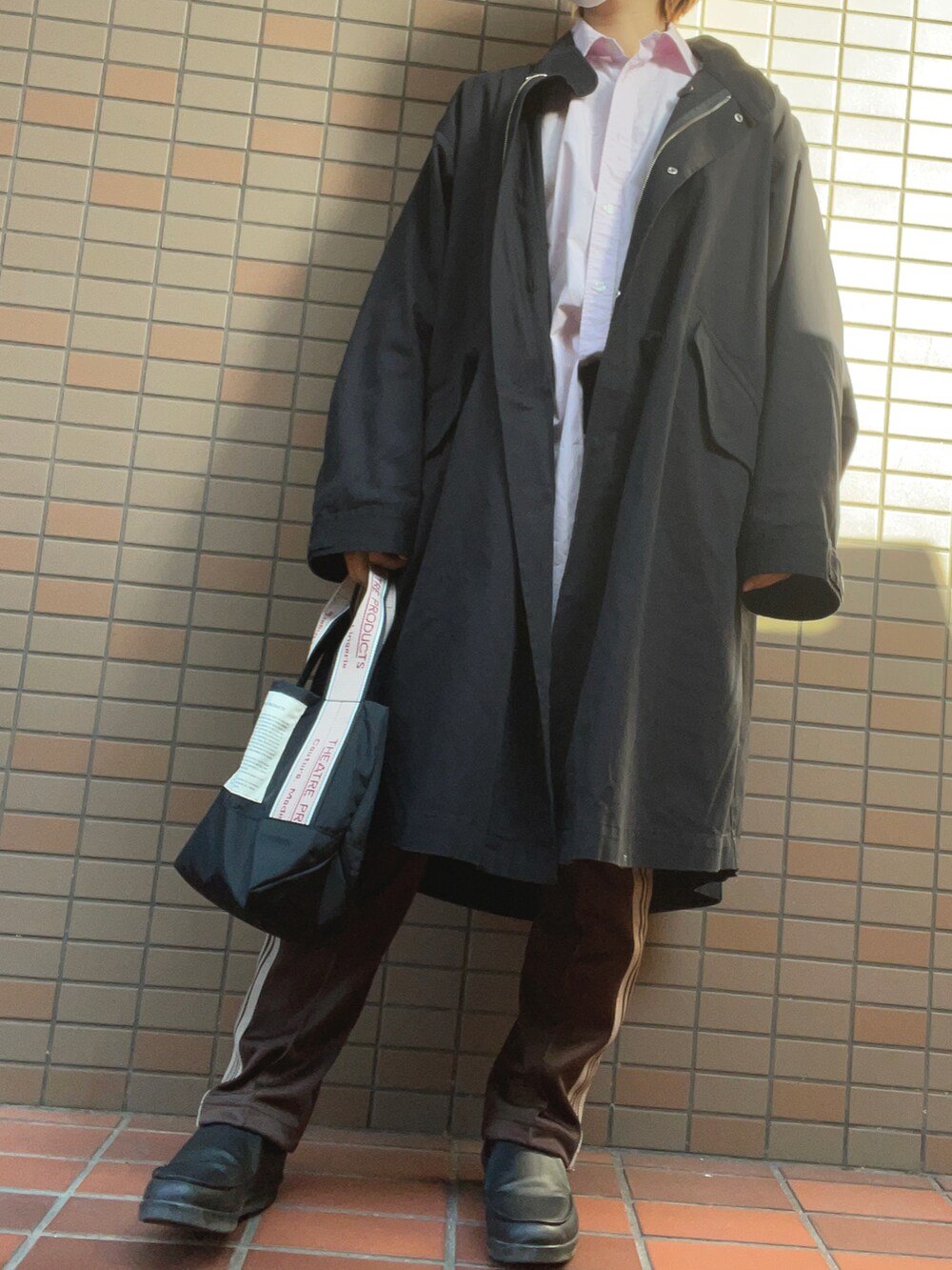 ブラック系のトートバッグ、ブラック系のスニーカー、ブラウン系のその他パンツを着用したレディースの秋コーディネートの2枚目の写真