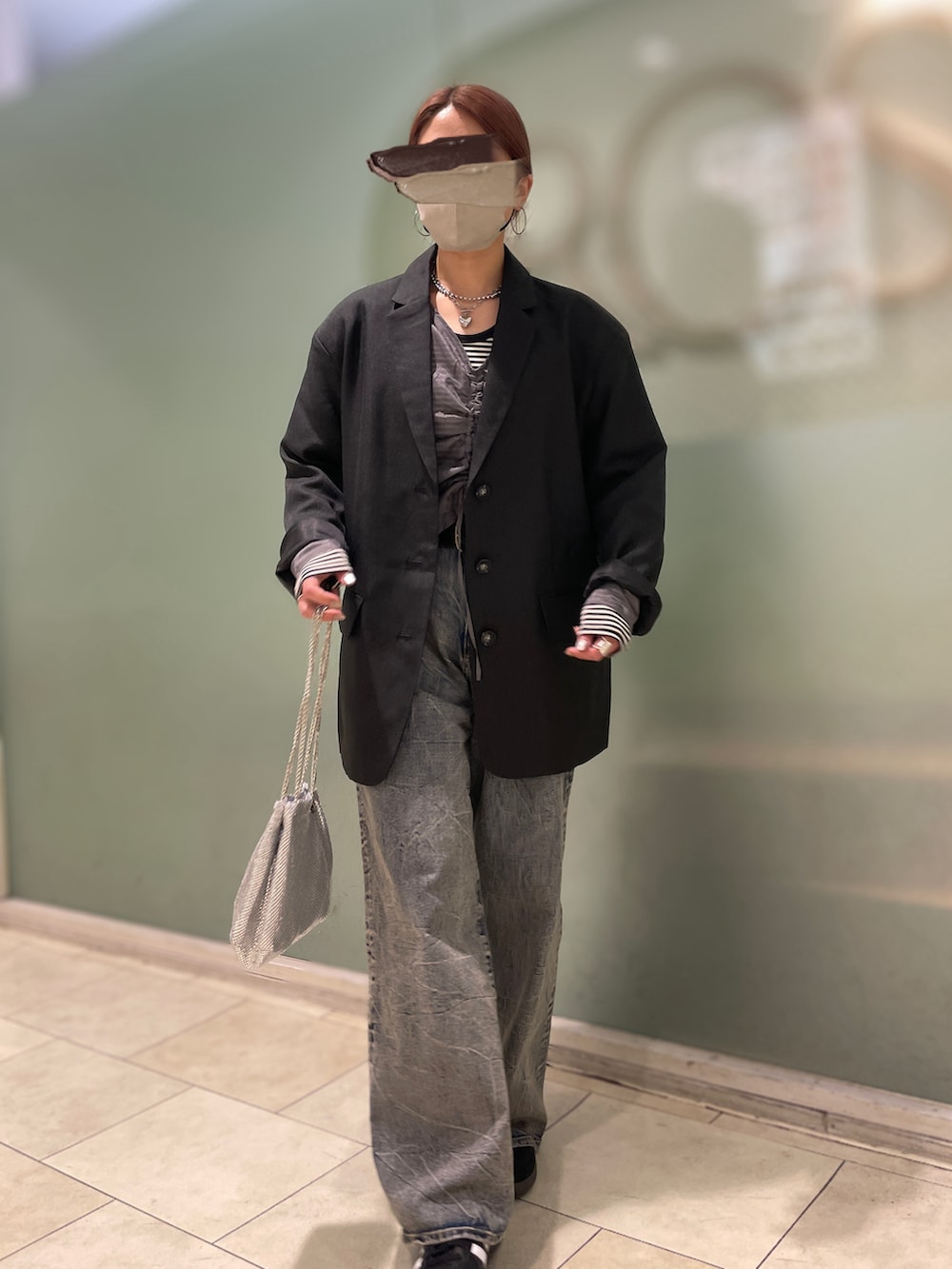 ブルー系のデニムパンツ、ブラック系のスニーカー、シルバー系のショルダーバッグを着用したレディースの春コーディネートの2枚目の写真