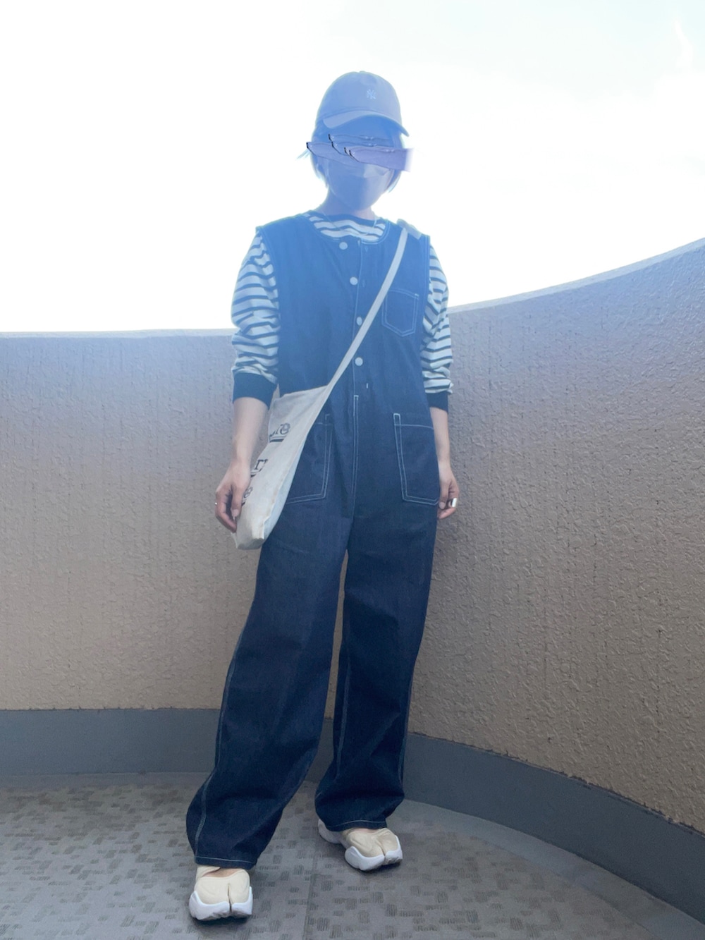 ブルー系のつなぎ/オールインワン、ベージュ系のショルダーバッグ、ブラック系のTシャツ/カットソーを着用したレディースの春コーディネートの2枚目の写真