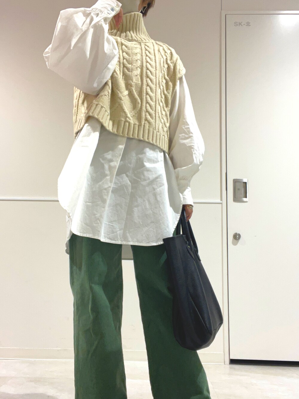 グレー系のその他パンツ、ブラック系のブーツ、ブラック系のトートバッグを着用したレディースの秋コーディネートの2枚目の写真