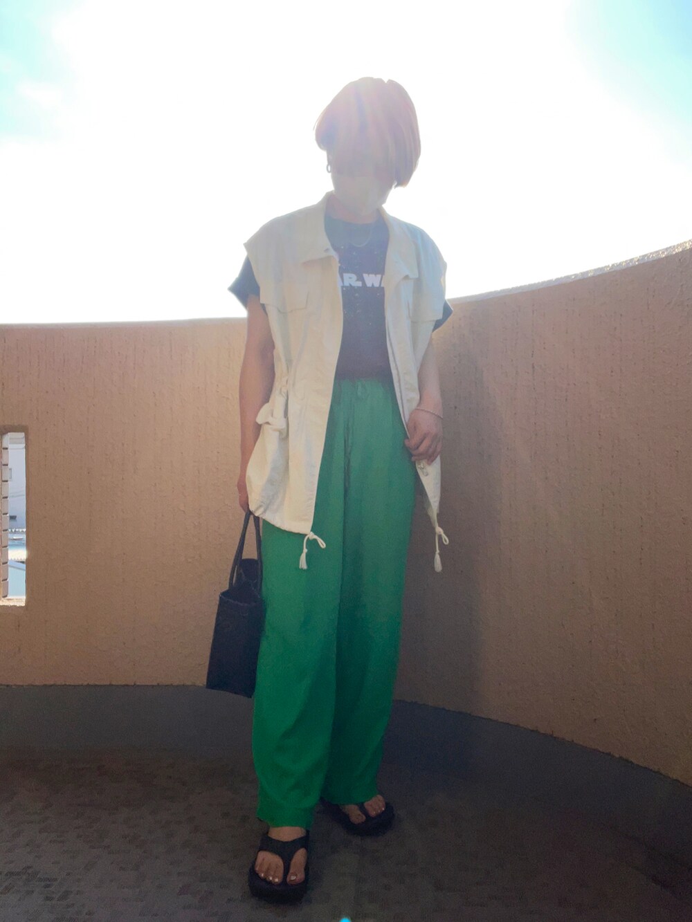 グリーン系のその他パンツ、ブラック系のサンダル、ホワイト系のベストを着用したレディースの夏コーディネートの2枚目の写真