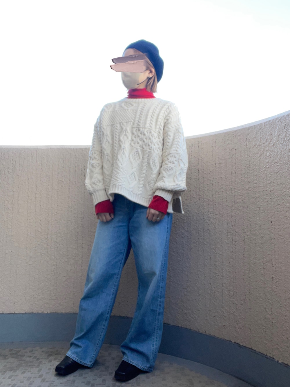 ブルー系のデニムパンツ、ブラック系のブーツ、ホワイト系のニット/セーターを着用したレディースの冬コーディネートの3枚目の写真