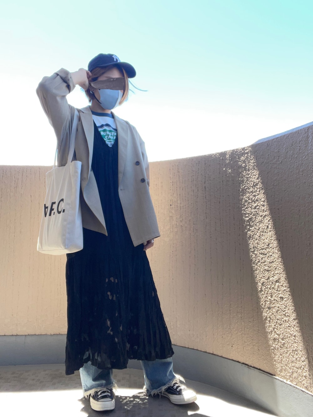 ホワイト系のトートバッグ、ブラック系のワンピース、その他のスニーカーを着用したレディースの夏コーディネートの2枚目の写真