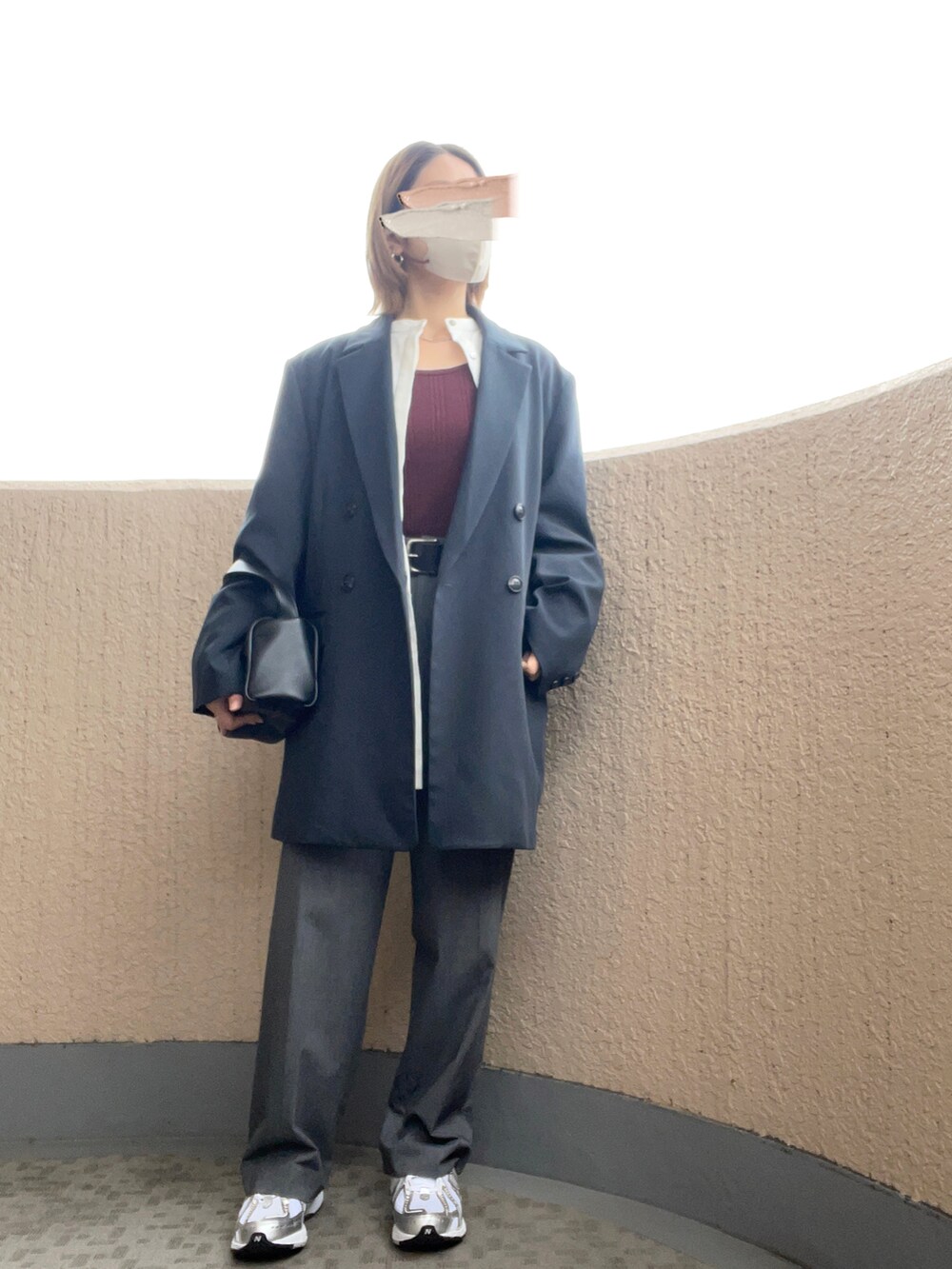 グレー系のスラックス、シルバー系のスニーカー、ブラック系のハンドバッグを着用したレディースの秋コーディネートの3枚目の写真