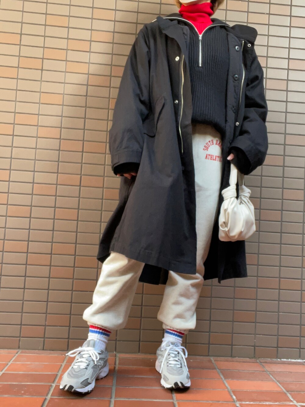 グレー系のスニーカー、ホワイト系のスウェットパンツ、ブラック系のニット/セーターを着用したレディースの冬コーディネートの3枚目の写真