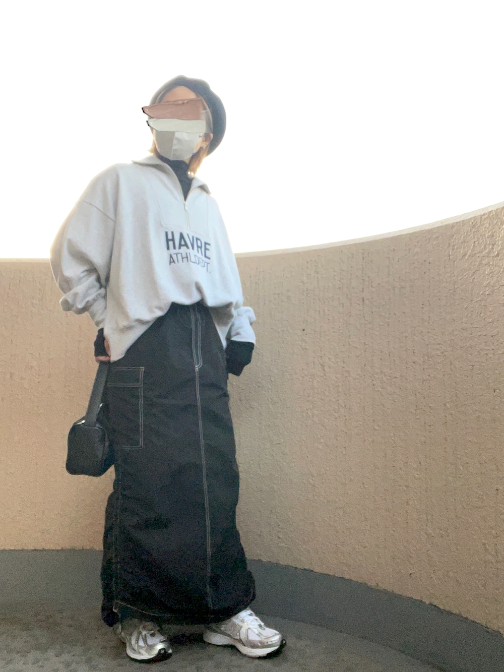 ブラック系のスカート、シルバー系のスニーカー、ブラック系のハンドバッグを着用したレディースの秋コーディネートの3枚目の写真