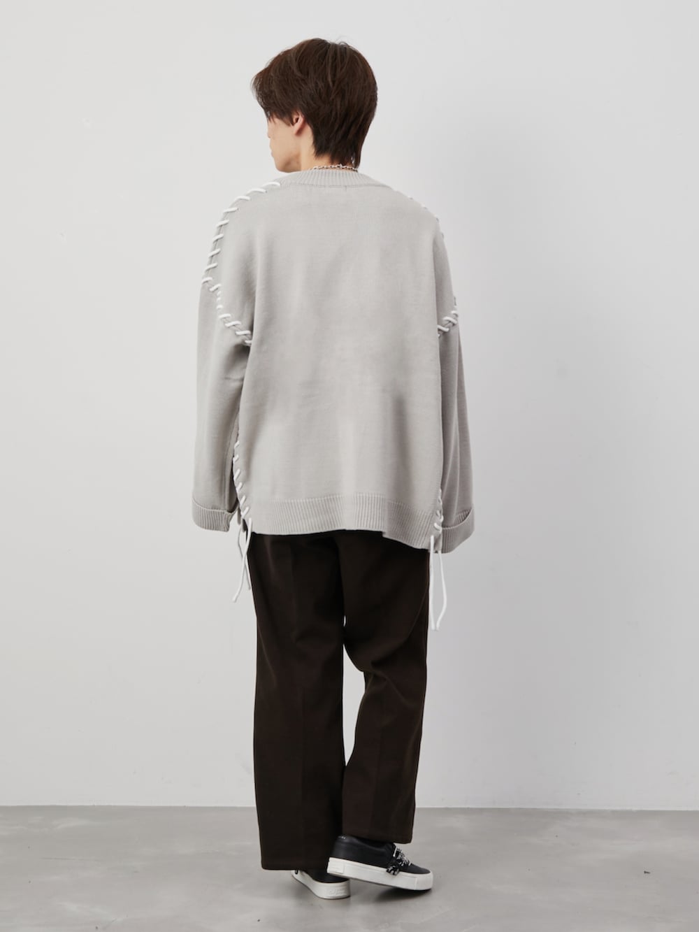 ベージュ系のカーディガン/ボレロ、ブラウン系のスラックス、ブラック系のベルトを着用したメンズの冬コーディネートの3枚目の写真