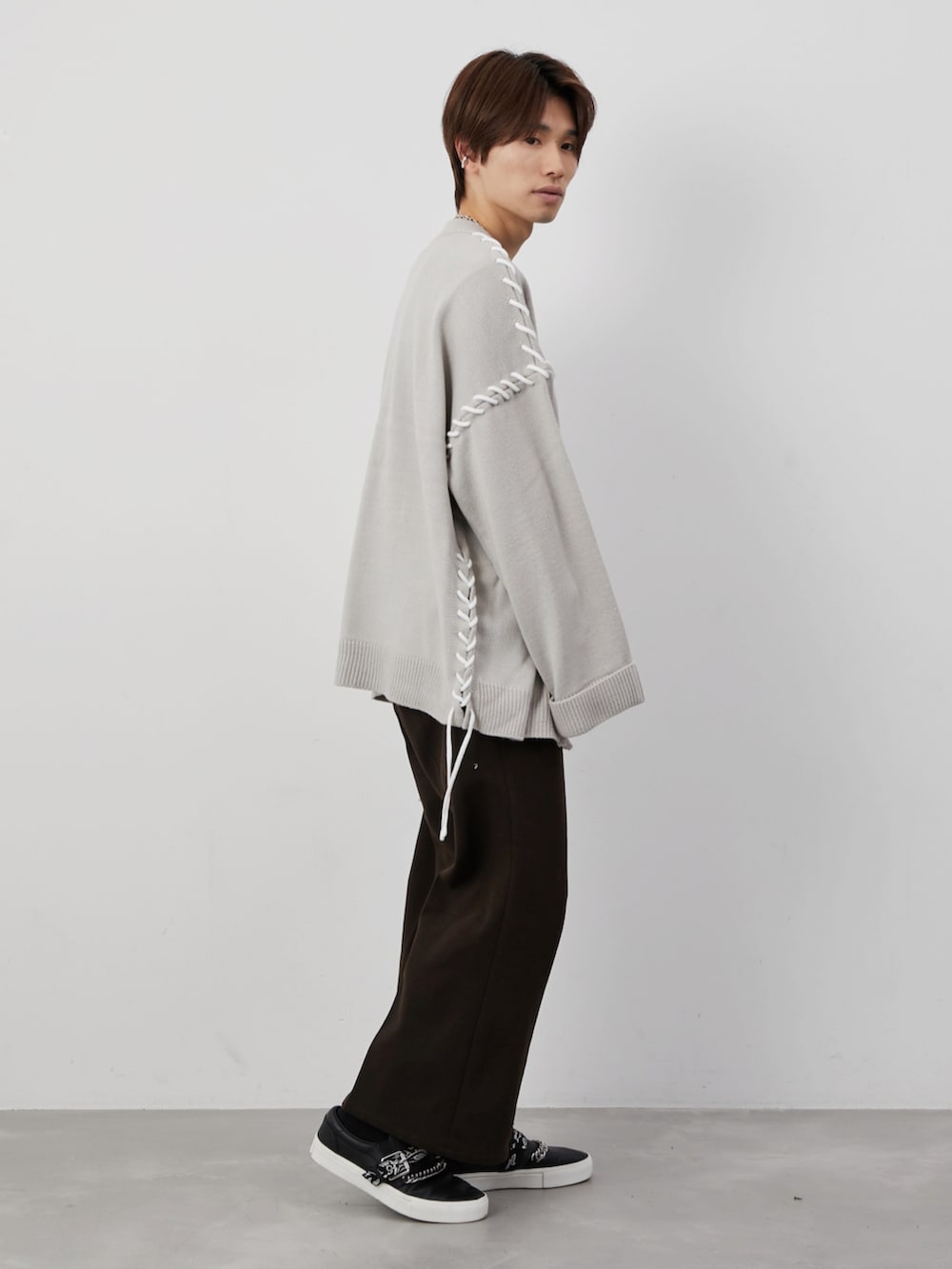 ベージュ系のカーディガン/ボレロ、ブラウン系のスラックス、ブラック系のベルトを着用したメンズの冬コーディネートの2枚目の写真