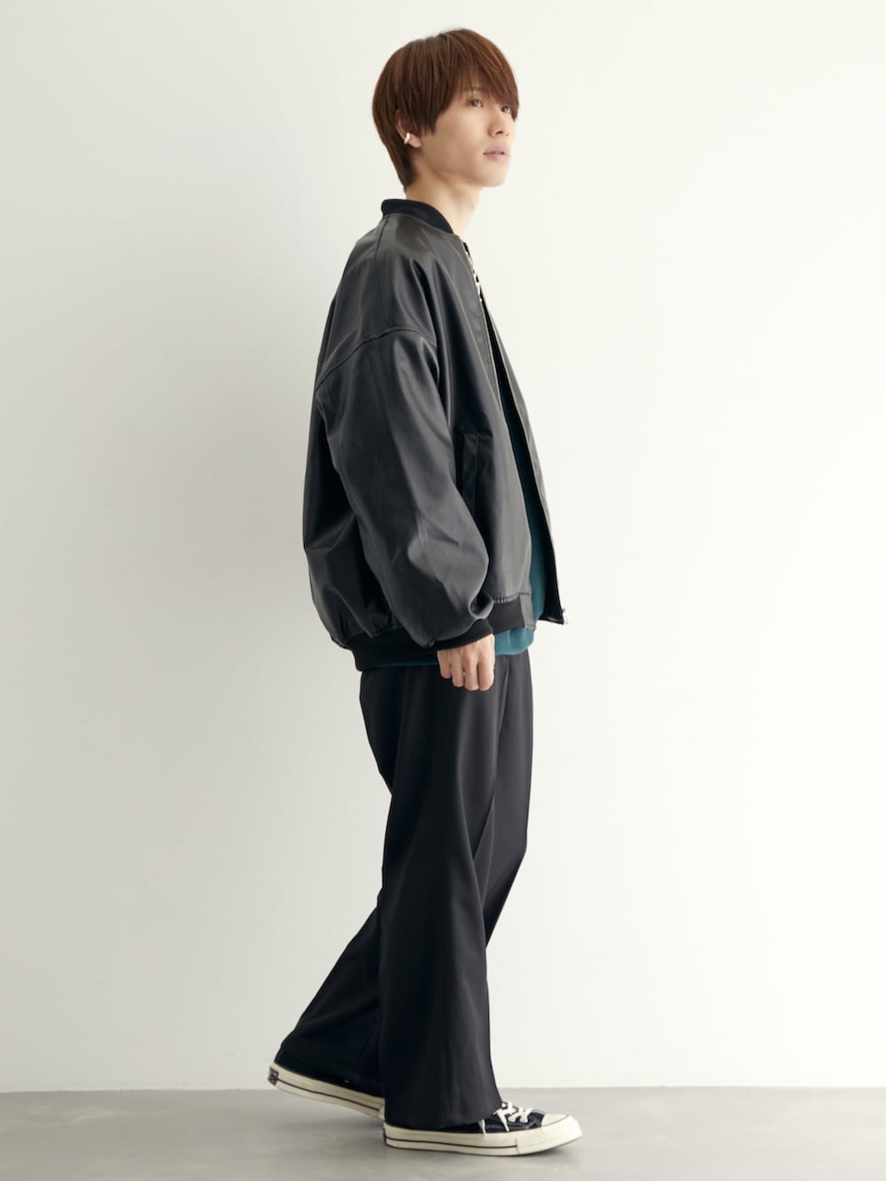 ブラック系のMA-1、グリーン系のスウェット、ブラック系のスラックスを着用したメンズの秋コーディネートの2枚目の写真