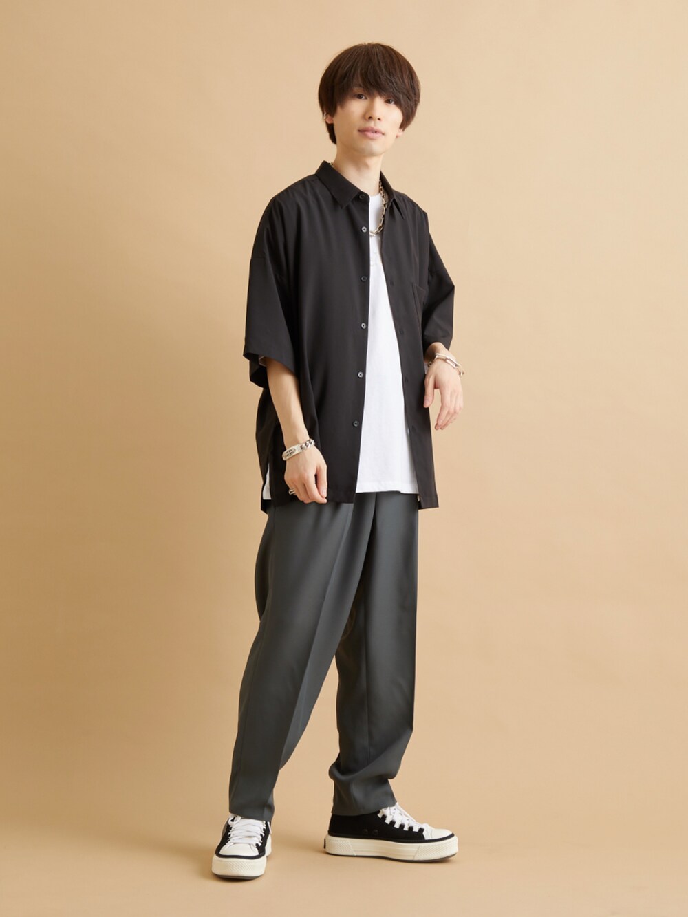 グリーン系のスラックス、ブラック系のシャツ/ブラウス、ホワイト系のTシャツ/カットソーを着用したメンズの夏コーディネートの2枚目の写真