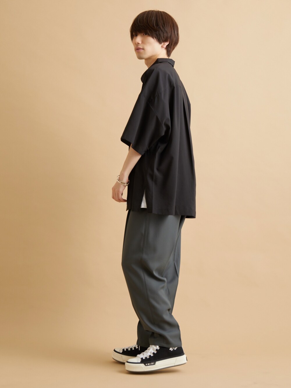 グリーン系のスラックス、ブラック系のシャツ/ブラウス、ホワイト系のTシャツ/カットソーを着用したメンズの夏コーディネートの3枚目の写真