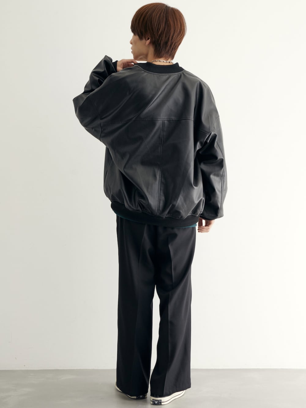 ブラック系のMA-1、グリーン系のスウェット、ブラック系のスラックスを着用したメンズの秋コーディネートの3枚目の写真