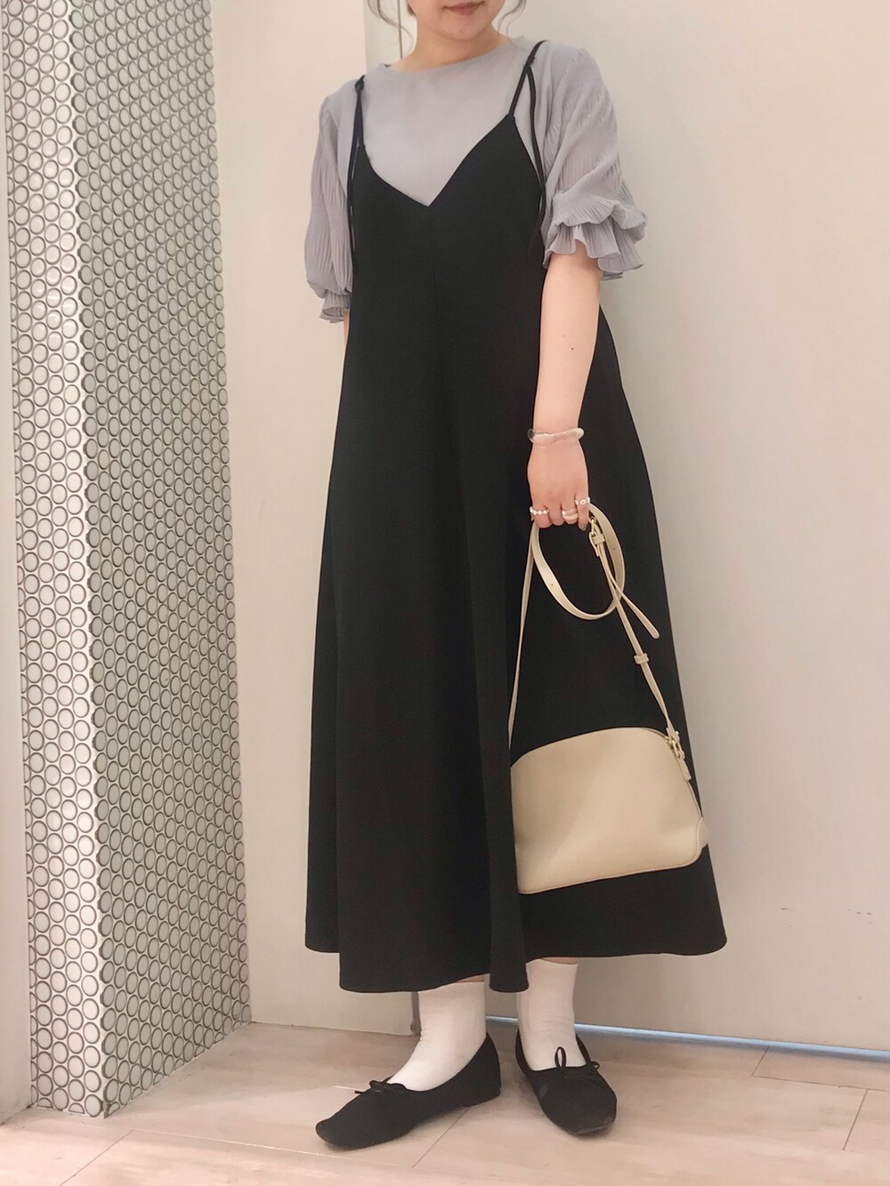 ブルー系のTシャツ/カットソー、ブラック系のワンピース、ベージュ系のショルダーバッグを着用したレディースの秋コーディネートの2枚目の写真