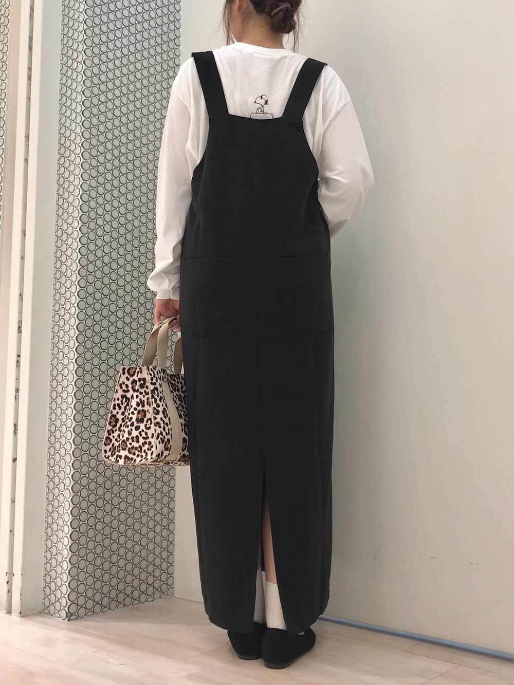 ブルー系のカーディガン/ボレロ、ホワイト系のTシャツ/カットソー、ブラック系のジャンパースカートを着用したレディースの秋コーディネートの2枚目の写真