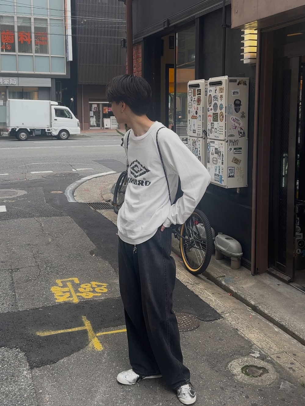 ブラック系のデニムパンツ、ホワイト系のTシャツ/カットソー、シルバー系のスニーカーを着用したメンズの夏コーディネートの4枚目の写真