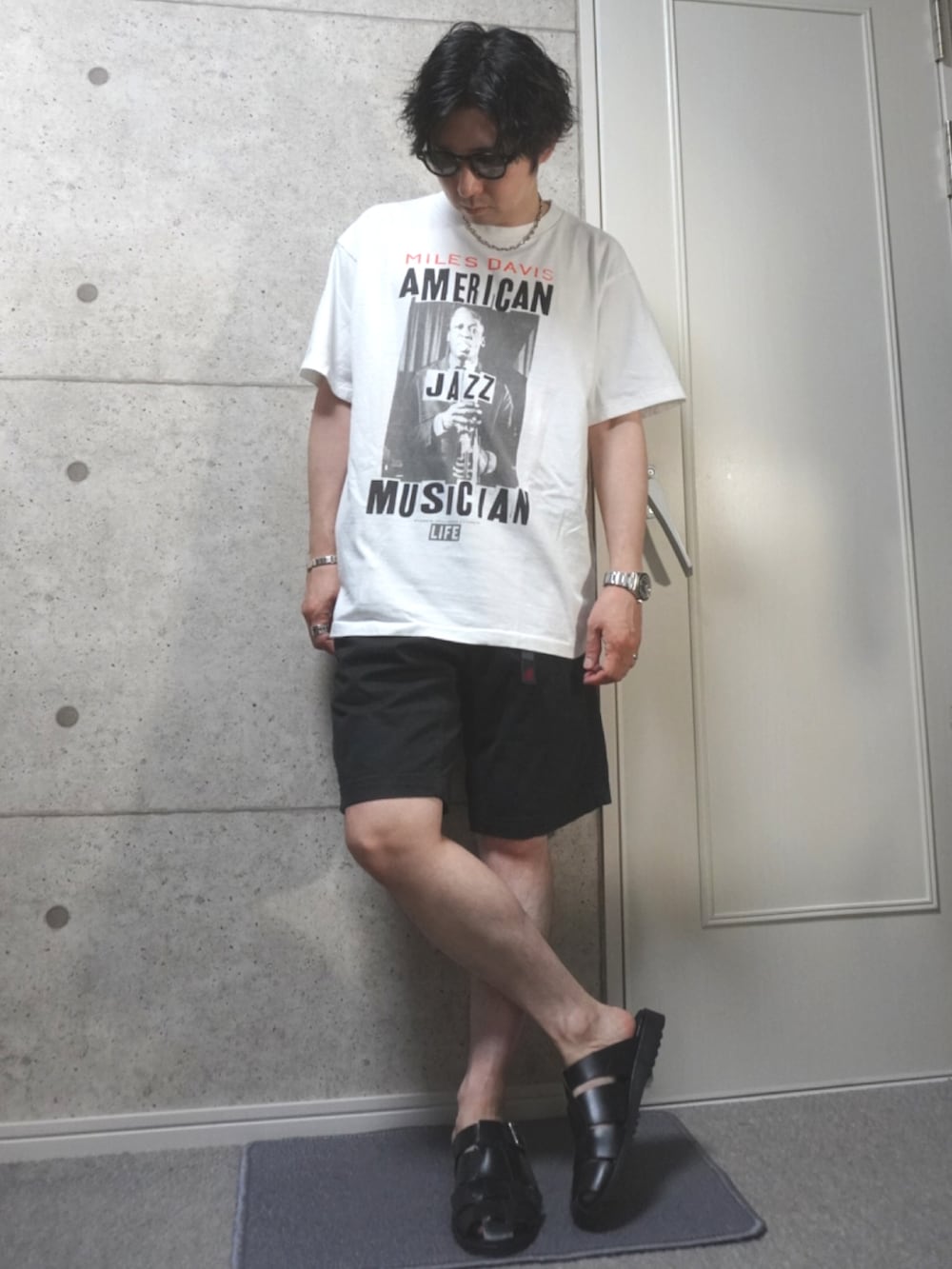 ブラック系のサンダル、ブラック系のその他パンツ、ブラウン系のサングラスを着用したメンズの夏コーディネートの2枚目の写真