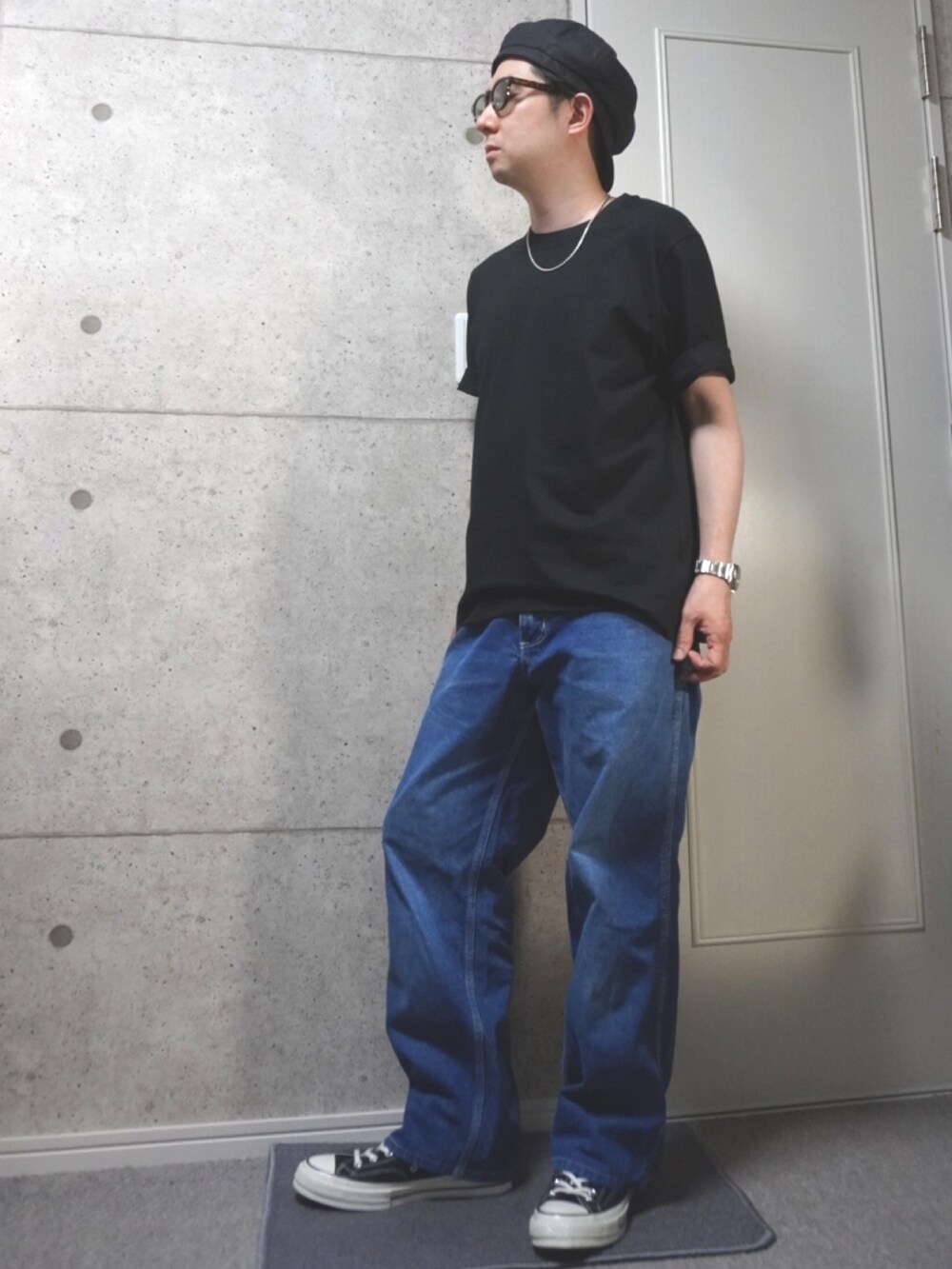 ブラック系のTシャツ/カットソー、ブルー系のデニムパンツ、ブラック系のスニーカーを着用したメンズの夏コーディネートの2枚目の写真