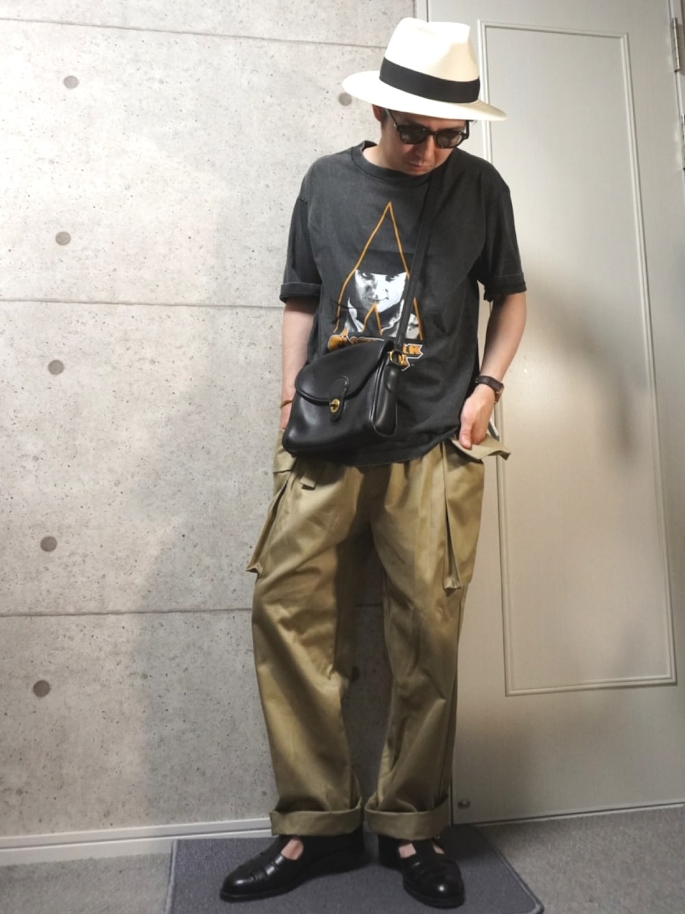 ブラック系のTシャツ/カットソー、ブラック系のショルダーバッグ、ブラック系のサンダルを着用したメンズの夏コーディネートの2枚目の写真