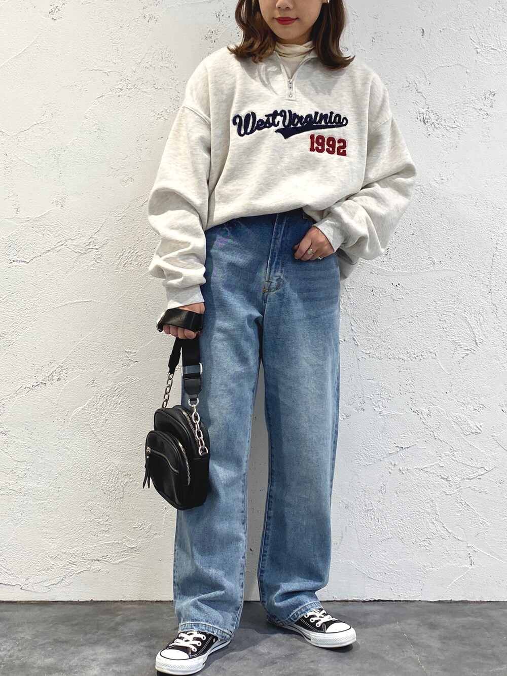 ホワイト系のTシャツ/カットソー、ブルー系のデニムパンツ、ブラック系のショルダーバッグを着用したレディースの冬コーディネートの2枚目の写真