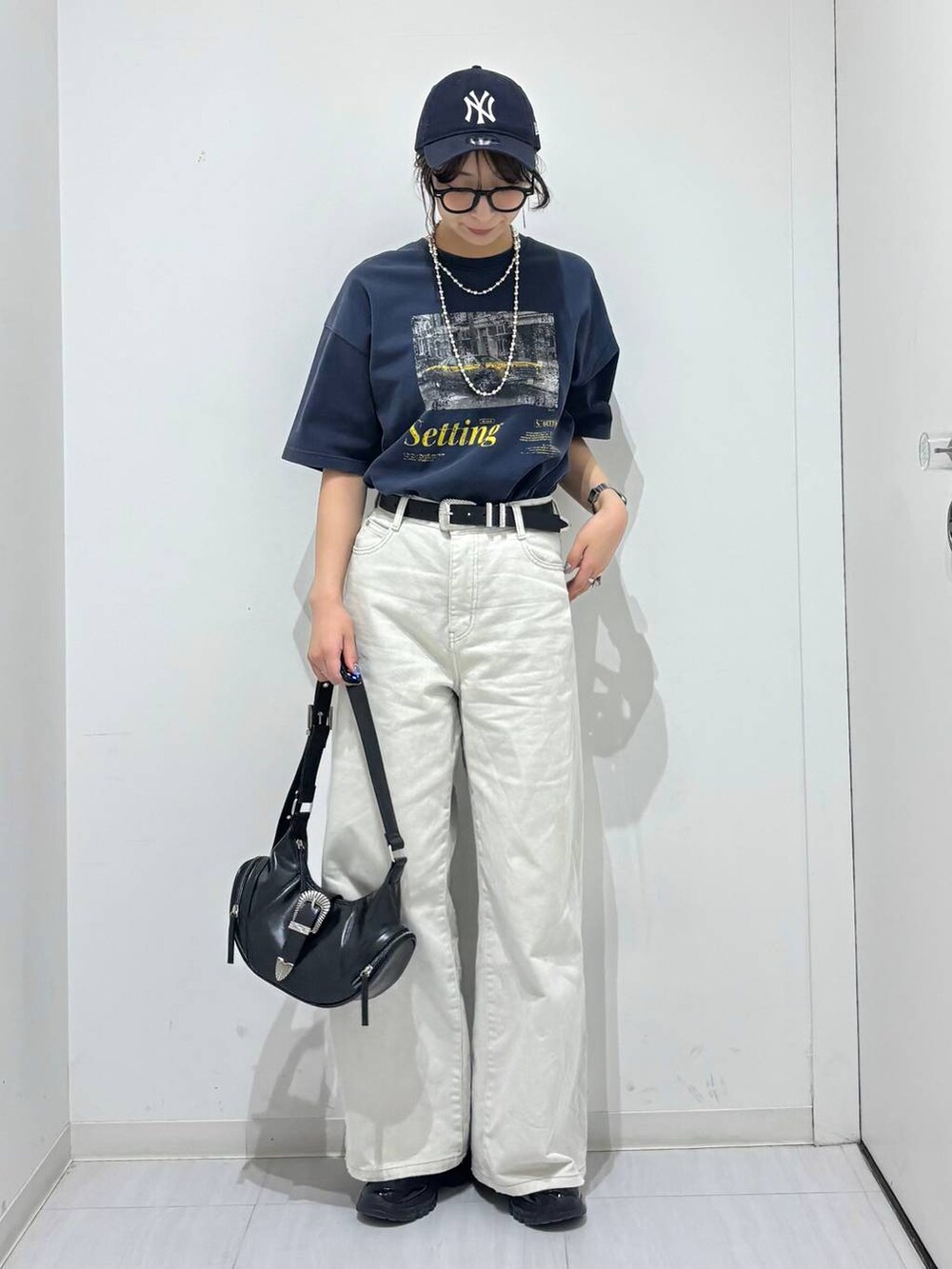 グレー系のデニムパンツ、ブラック系のスニーカー、ブルー系のTシャツ/カットソーを着用したレディースの春コーディネートの5枚目の写真