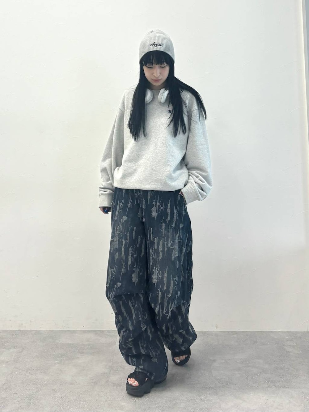 ブルー系のデニムパンツ、グレー系のスウェット、グレー系のニットキャップ/ビーニーを着用したレディースの秋コーディネートの2枚目の写真