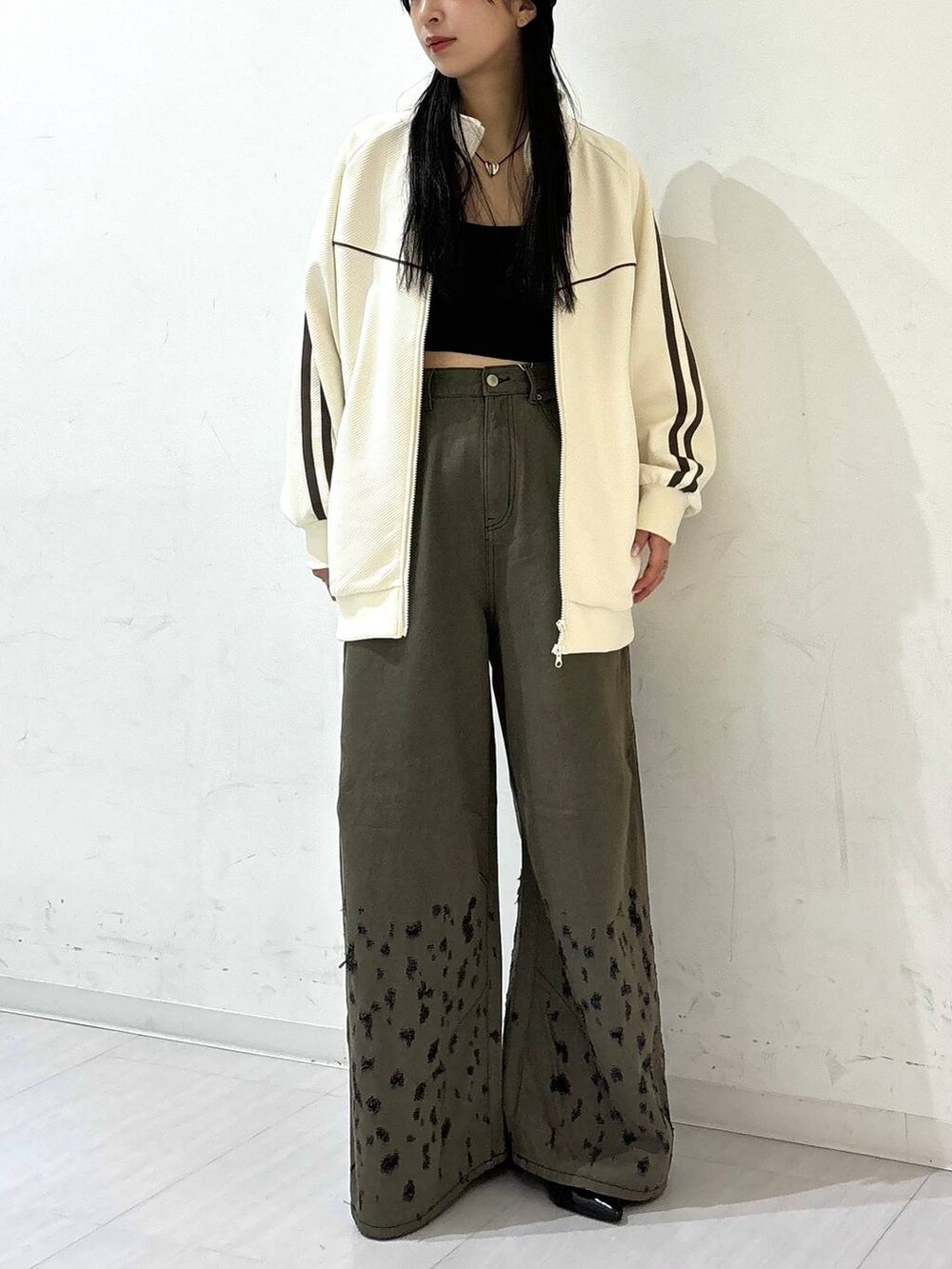 ブラック系のパンプス、ブラック系のデニムパンツ、ホワイト系のジャージを着用したレディースの夏コーディネートの2枚目の写真