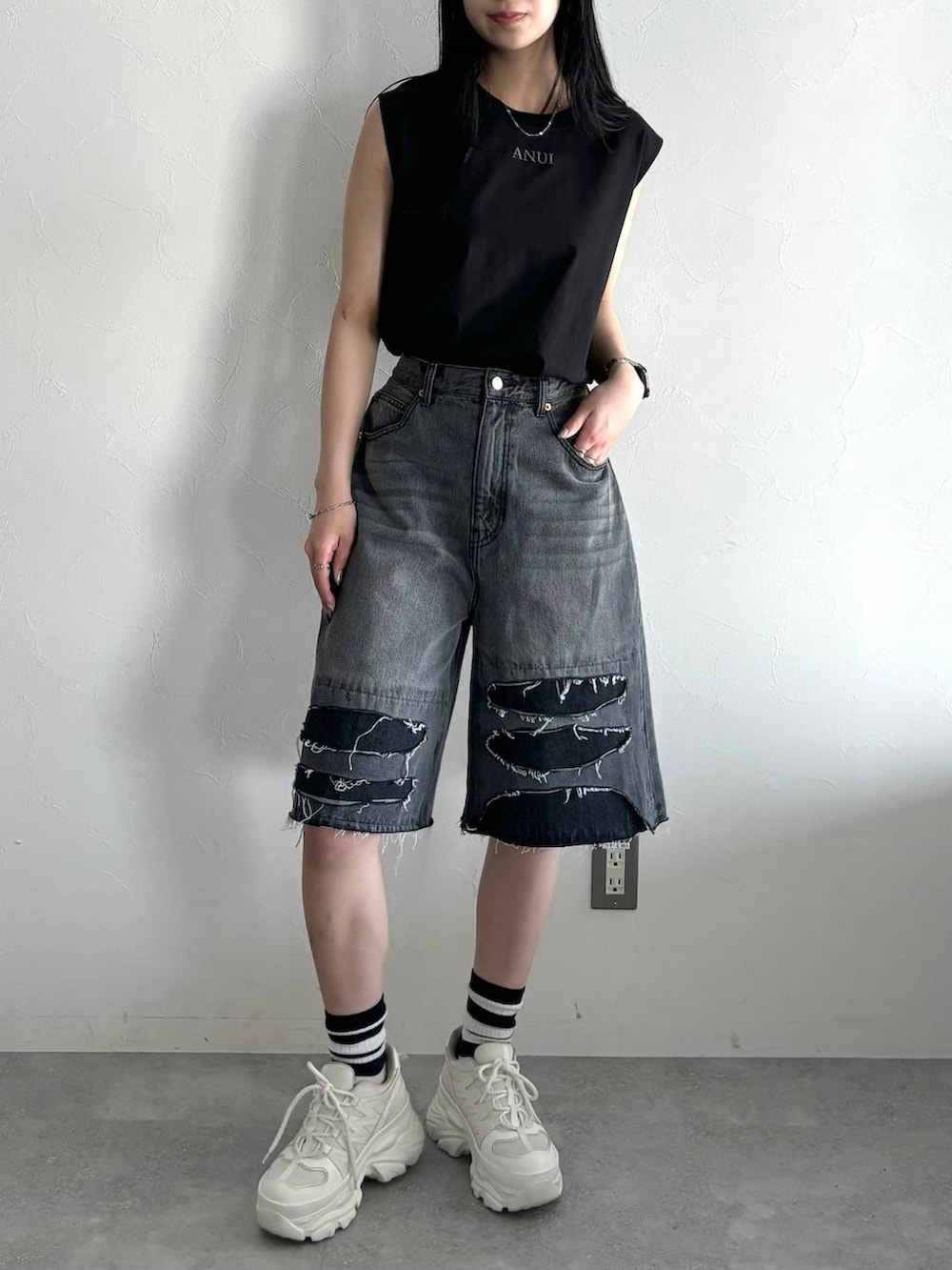 ホワイト系のスニーカー、ブラック系のデニムパンツ、ブラック系のTシャツ/カットソーを着用したレディースの春コーディネートの2枚目の写真